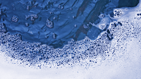 Detailansicht der Grenze zwischen Wasser und weißer Seifenlauge Detailansicht der Grenze zwischen Wasser und weißer Seifenlauge